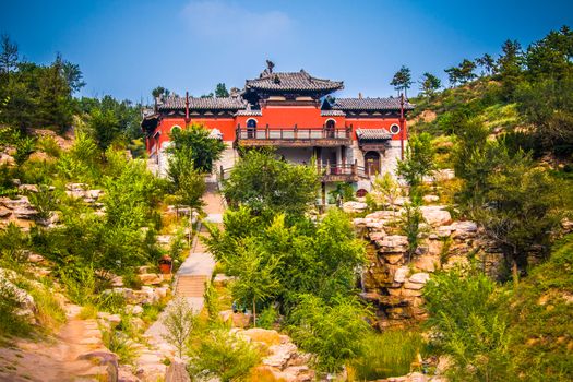 A buddhist monastery on top of a cliff under going renovations.