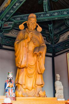 Buddhist diety, giant statue carved in wood and house in a temple.