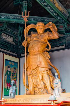 Buddhist diety, giant statue carved in wood and house in a temple.