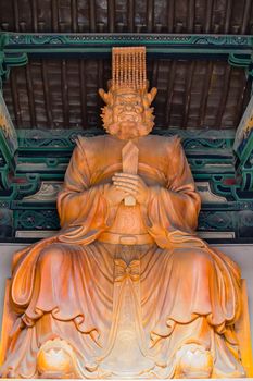 Buddhist diety, giant statue carved in wood and house in a temple.