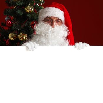 Santa Claus holding white paper billboard with copy space for text