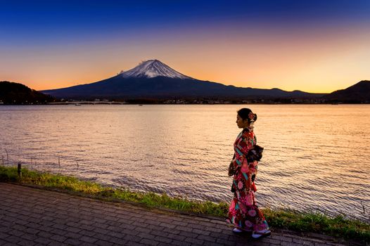 Asian woman wearing japanese traditional kimono at Fuji mountain. Sunset at Kawaguchiko lake in Japan.