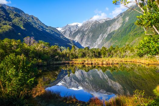 Franz Josef glacier reflecting in a lake, New Zealand