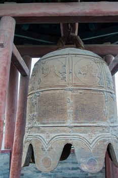 Close up of an ancient, Ming Dynasty bell still hanging in it's tower.