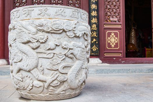 A giant Ming Dynasty stone urn with a double dragon motif adorns the entrance way to a prayer room.