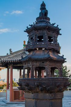 A pagoda shaped fire pit in a temple's frount court yard blackened from years burning offerings during various ceremonies.