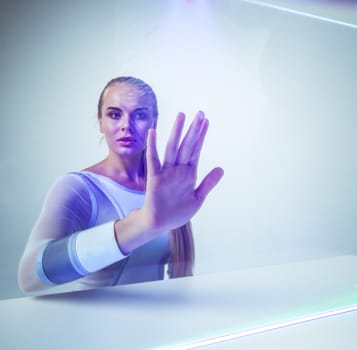 Young woman touching virtual glowing display