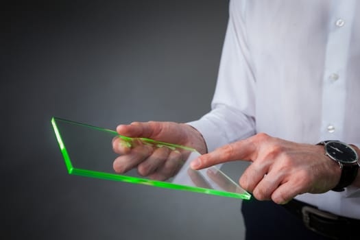 Male hands holding blank futuristic transparent digital tablet pc computer with copy space