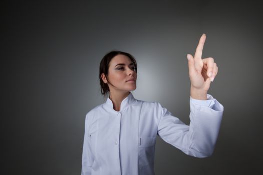 Female scientist or doctor pointing to futuristic display