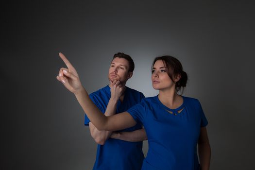 Healthcare, medicine and technology concept - two doctors pointing to something or pressing imaginary button