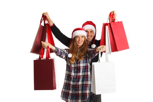 Happy beautiful couple holding many bags with christmas gifts isolated on white background