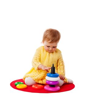 Baby sitting playing with pyramid isolated on white