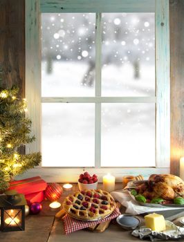 Christmas turkey and pie with gift boxes next to a window overlooking a winter forest background