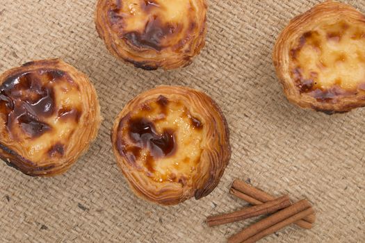 Famous Portuguese egg pastry tart called 'Pastel de Belem' on hessian fabric.