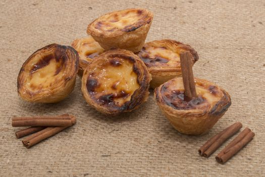 Famous Portuguese egg pastry tart called 'Pastel de Belem' on hessian fabric.