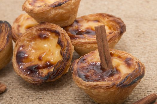 Famous Portuguese egg pastry tart called 'Pastel de Belem' on hessian fabric.