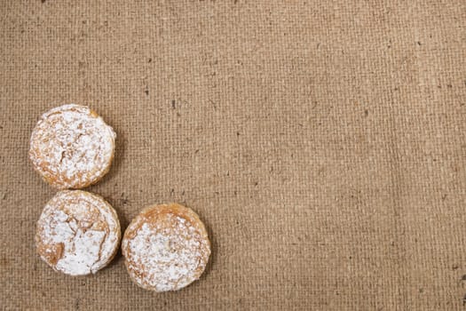 Famous Portuguese flaky Bean pastry sprinkled with white sugar powder on hessian fabric.