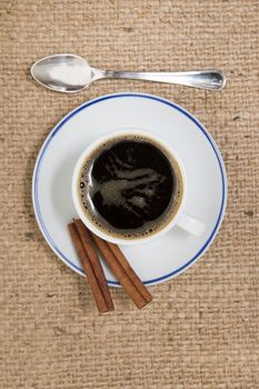 espresso coffee with cinnamon over a hessian fabric background.