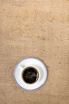 Top view of espresso coffee over a hessian fabric background.