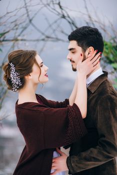 groom in a brown and bride in burgundy in the mountains Carpathians