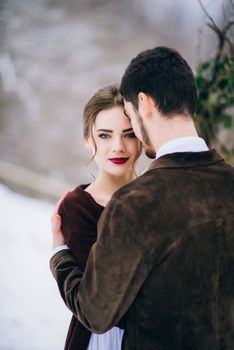 groom in a brown and bride in burgundy in the mountains Carpathians