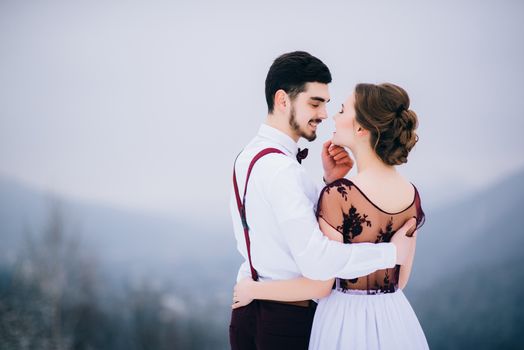 groom in a brown and bride in burgundy in the mountains Carpathians