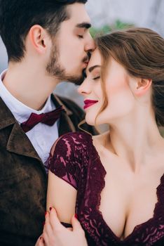 groom in a brown and bride in burgundy in the mountains Carpathians