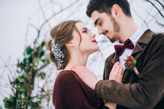 groom in a brown and bride in burgundy in the mountains Carpathians