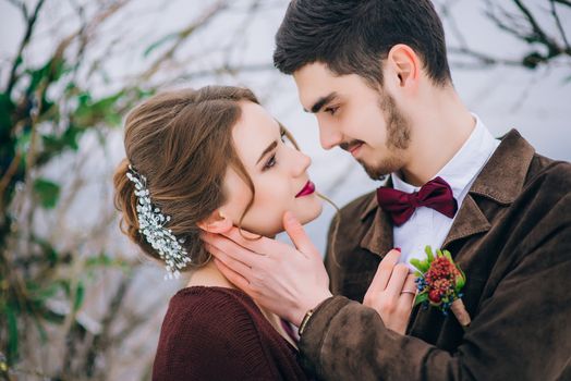 groom in a brown and bride in burgundy in the mountains Carpathians