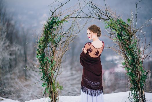 groom in a brown and bride in burgundy in the mountains Carpathians