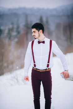 groom in a brown and bride in burgundy in the mountains Carpathians