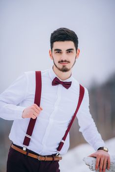 groom in a brown and bride in burgundy in the mountains Carpathians