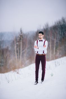 groom in a brown and bride in burgundy in the mountains Carpathians