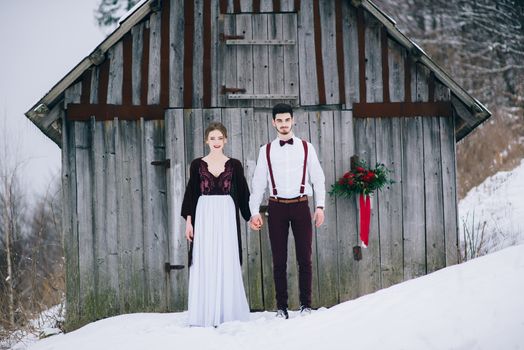 groom in a brown and bride in burgundy in the mountains Carpathians