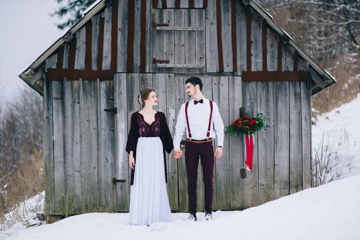 groom in a brown and bride in burgundy in the mountains Carpathians