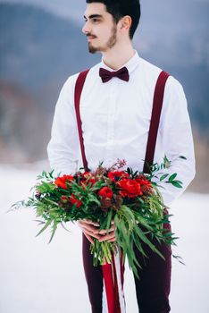 groom in a brown and bride in burgundy in the mountains Carpathians