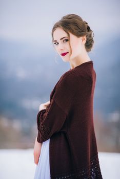 groom in a brown and bride in burgundy in the mountains Carpathians