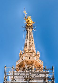 Golden Madonna statue, aka Madonnina, on the rooftop of the gothic Cathedral, the most iconic landmark of Milan, Italy