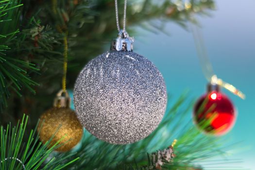 Christmas tree decorated with colourful baubles on the beach in summer.  shallow dof
