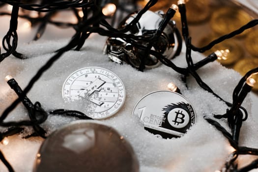 Digital currency physical metal bitcoin coin. Crypto currency christmas snow composition.