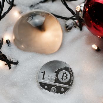 Digital currency physical metal bitcoin coin. Crypto currency christmas snow composition.