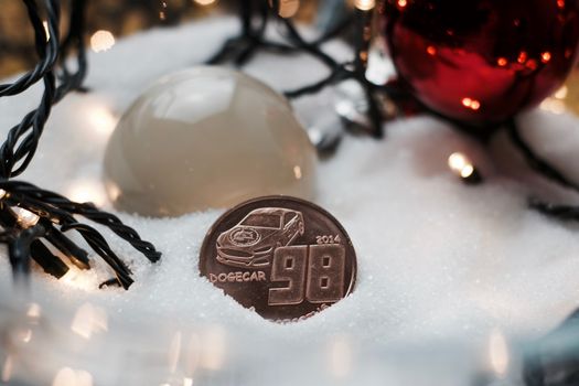 Digitl currency physical metal brass dogecoin coin. Christmas snow concept.