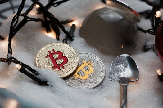 Digital currency physical metal bitcoin coin. Crypto currency christmas snow composition.