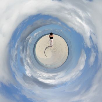 A young woman standing at the beach of a Maldivian island from a tiny world perspective