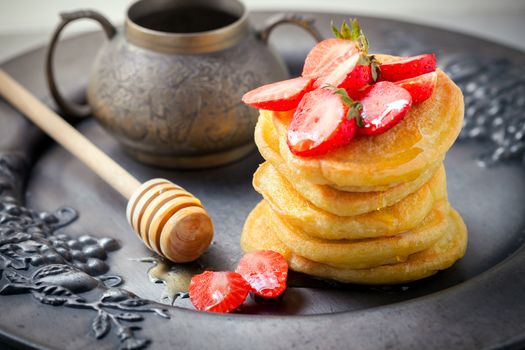 Stack of sweet pancakes with strawberry and honey. Gluten free flour.