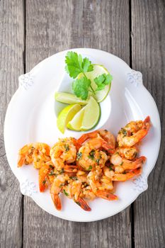 Fried Prawns with lemon served on a wooden surface