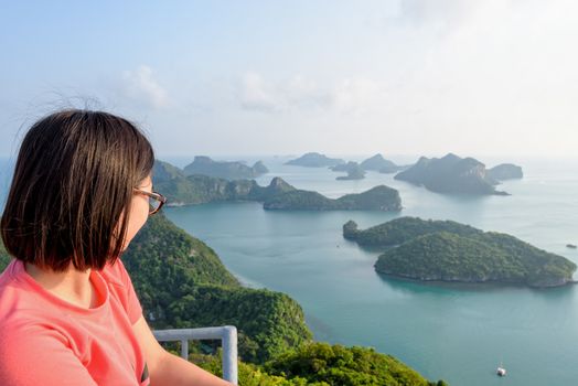 Woman tourist on the balcony is peak view point of Ko Wua Ta Lap island looking beautiful nature landscape during sunrise over the sea in Mu Ko Ang Thong National Park, Surat Thani, Thailand