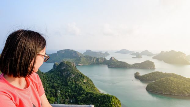 Woman tourist on peak view point of Ko Wua Ta Lap island looking beautiful nature landscape during sunrise over the sea in Mu Ko Ang Thong National Park, Surat Thani, Thailand, 16:9 widescreen