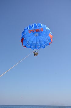 Flight on a parachute over the water high in the sky