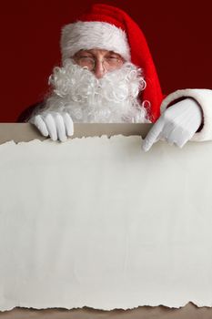 Santa Claus holding vintage paper billboard with copy space for text